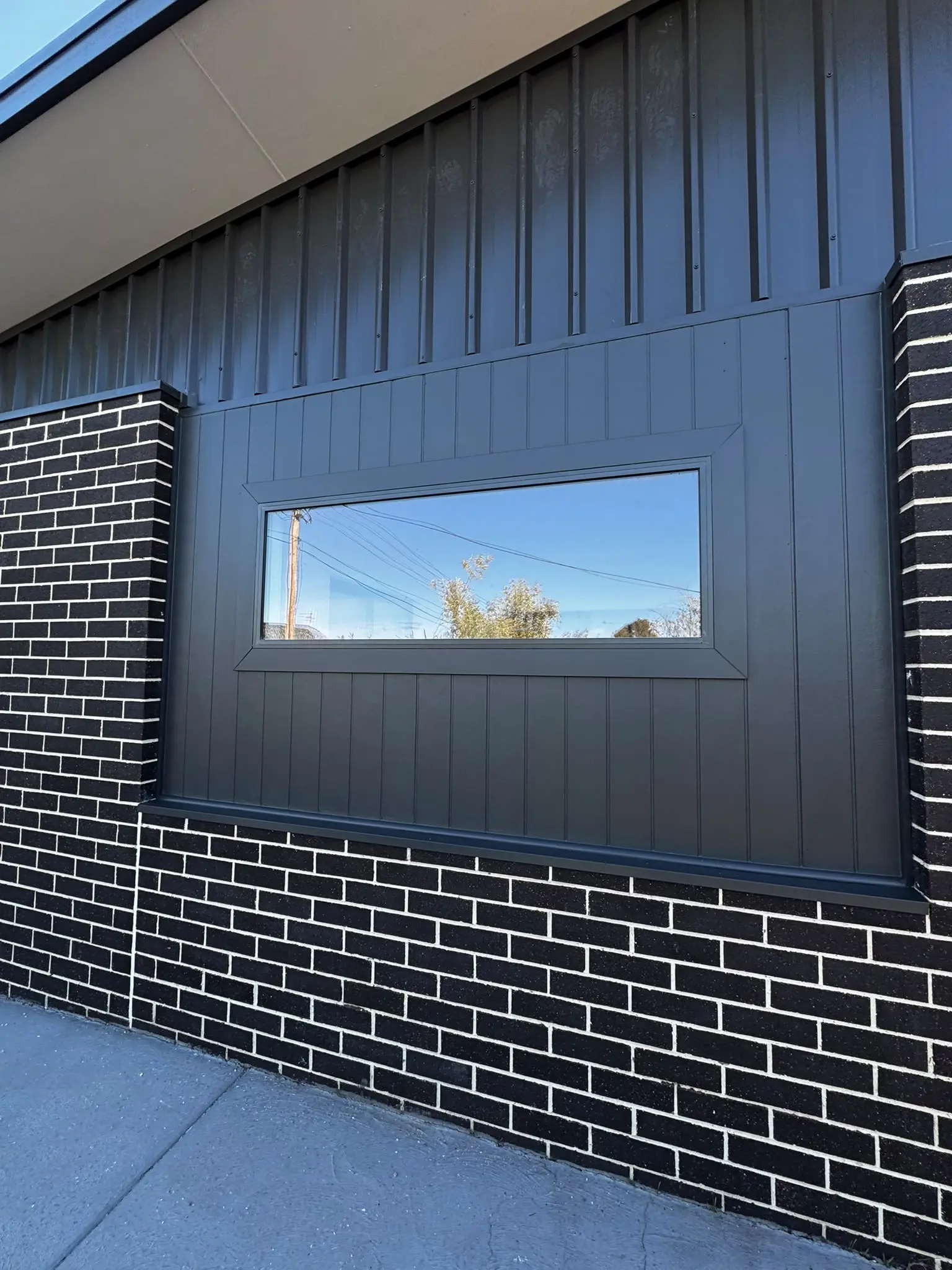 Exterior repaint with dark charcoal cladding and black brick in Belconnen