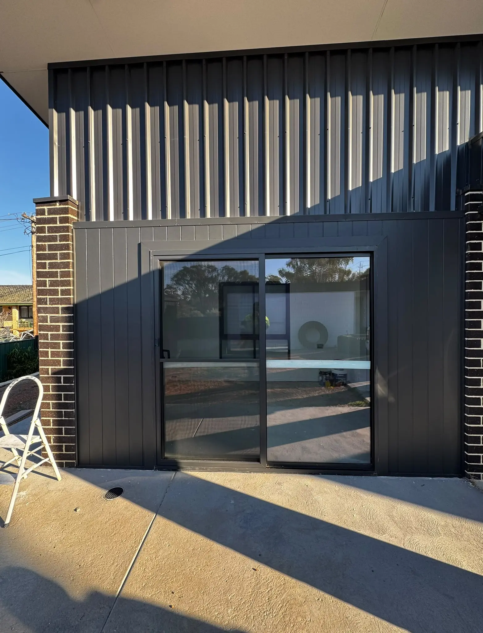 Exterior sliding door and dark cladding painted in Belconnen