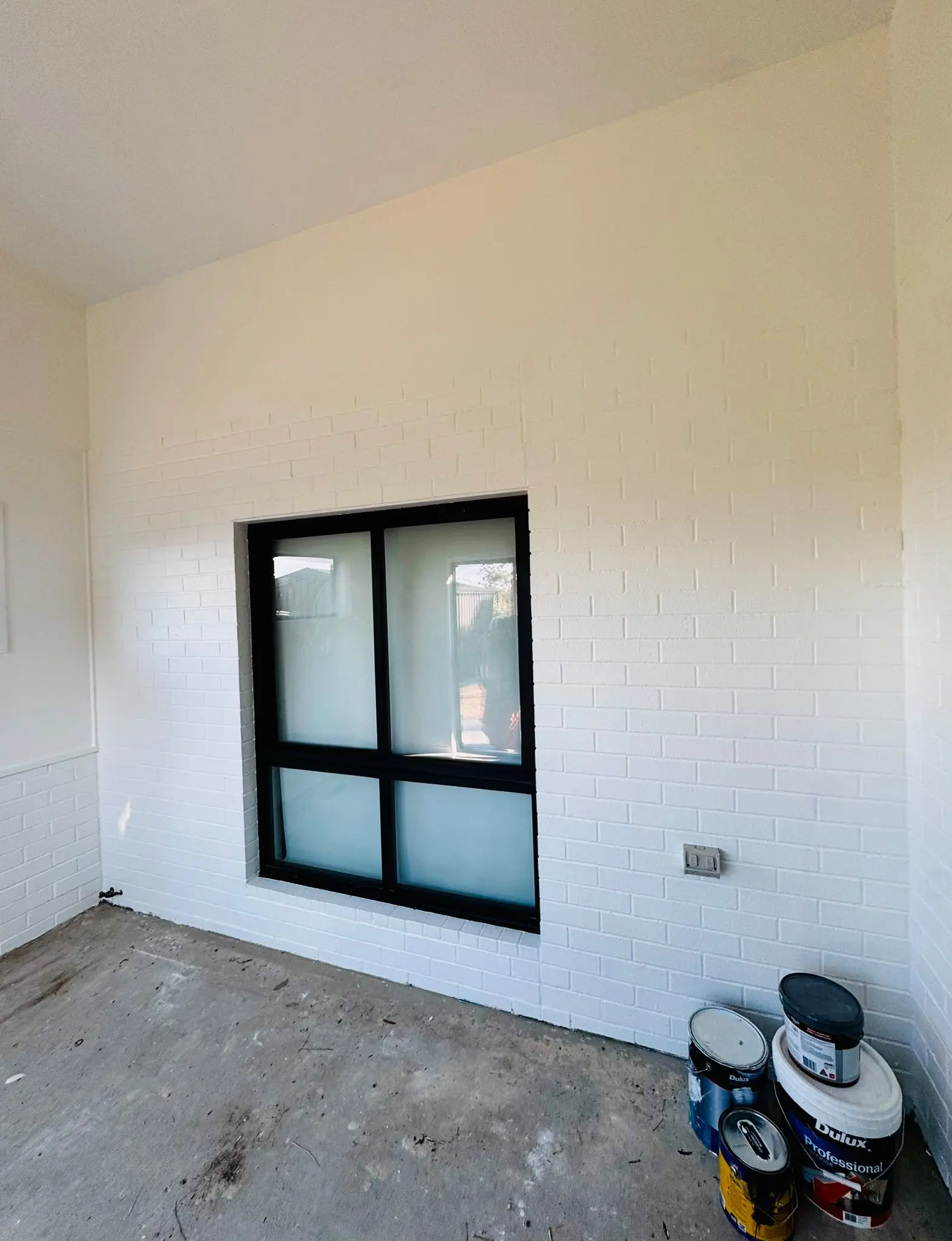 Painted white brick wall with black window frame in Belconnen